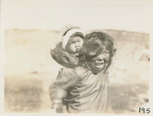 Image of Eskimo [Inuk] girl with baby sister in hood
